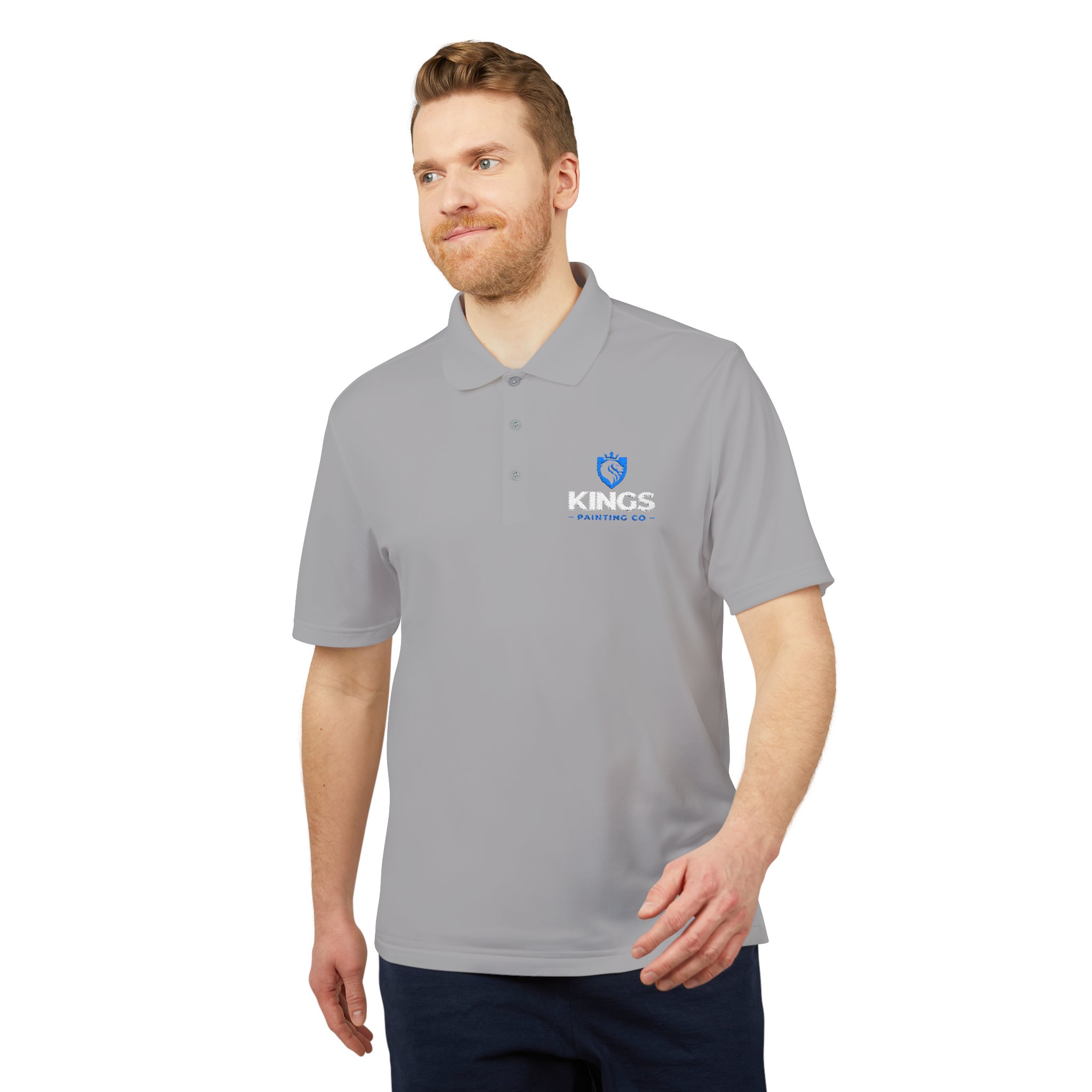 Man with light brown hair and beard wearing a light gray Kings Painting Co. Performance Polo by Under Armour®, standing and smiling against a plain white background.