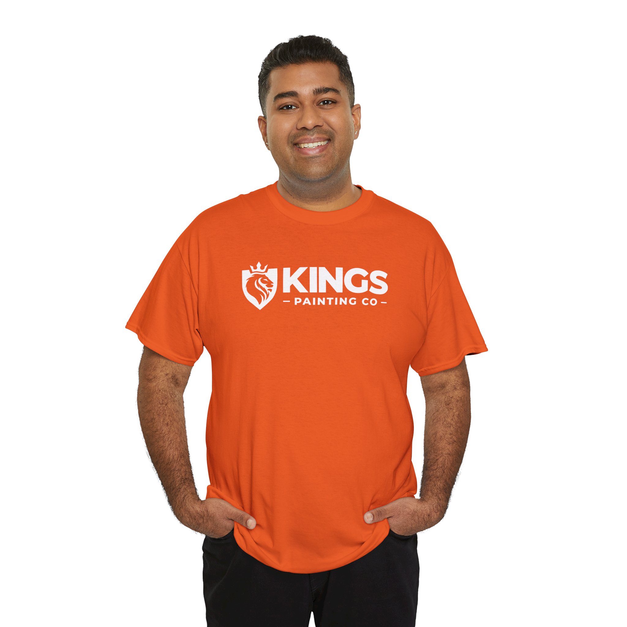A person smiling and wearing the Kings Painting Co. Logo T‑Shirt (Classic) | Gildan Ultra Cotton (G5000) in orange, featuring the company logo and shield graphic, stands against a white background.