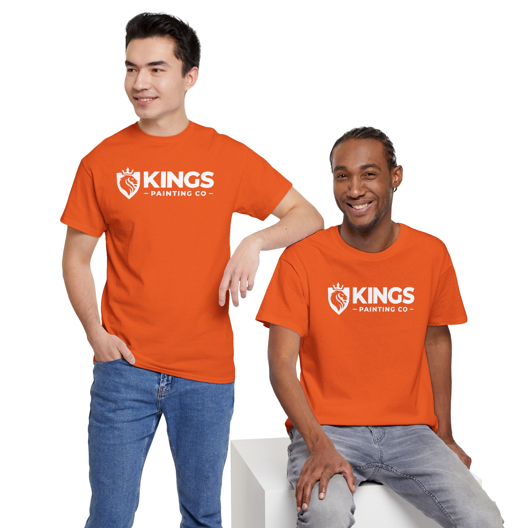 Two men smiling, wearing bright orange Kings Painting Co. Logo T‑Shirts (Classic) | Gildan Ultra Cotton (G5000). One stands with a hand in his pocket, while the other sits casually on a white block against a white background.